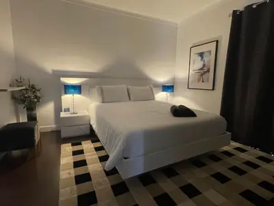 a bedroom with a large white bed and blue lamps at Villa Madeira island in Caniço
