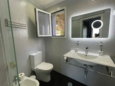 a bathroom with a toilet and a sink and a mirror at Villa Madeira island in Caniço