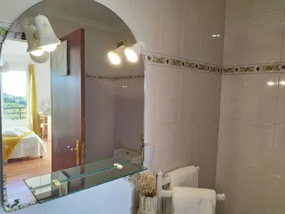 a bathroom with a sink and a mirror and a bed at MCStylo - Varandas Falésia in Caniço