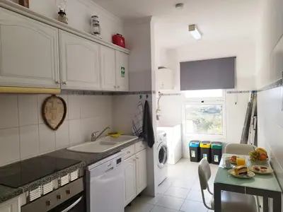 a white kitchen with a sink and a dishwasher at MCStylo - Varandas Falésia in Caniço