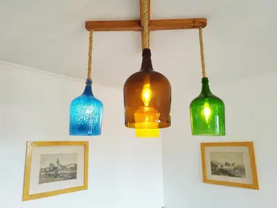 three glass lights hanging from a wall with pictures at MCStylo - Varandas Falésia in Caniço