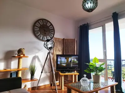 a living room with a clock on the wall and a tv at MCStylo - Varandas Falésia in Caniço