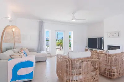 a living room with wicker chairs and a tv at Villa Sound of the Sea by Portugal Collection in Aljezur