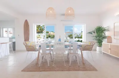 a white dining room with a table and chairs at Villa Sound of the Sea by Portugal Collection in Aljezur
