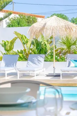 a group of chairs and an umbrella and a pool at Villa Sound of the Sea by Portugal Collection in Aljezur