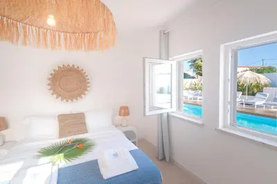 a bedroom with a bed with a view of a pool at Villa Sound of the Sea by Portugal Collection in Aljezur