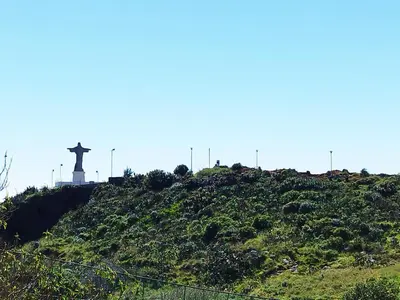 a statue of a cross on top of a hill at MCStylo-Ocean View in Caniço