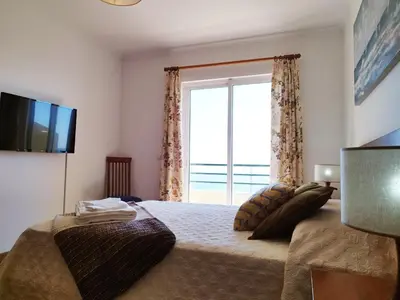 a bedroom with a bed with a large window at MCStylo-Ocean View in Caniço