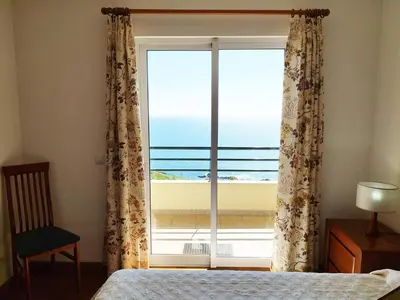 a bedroom with a window with a view of the ocean at MCStylo-Ocean View in Caniço