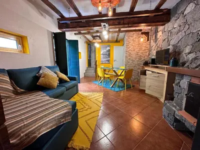 a living room with a blue couch and a table at Casa da Nogueira in Porto Moniz