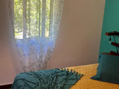 a bedroom with a bed and a window with a curtain at Casa da Nogueira in Porto Moniz