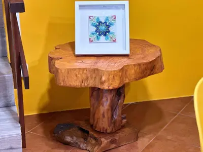 a picture frame sitting on top of a tree stump table at Casa da Nogueira in Porto Moniz