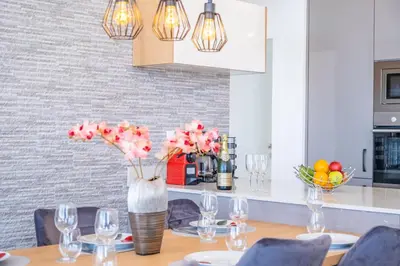 a dining room with a table with a vase of flowers at Villa Plumeria in Arco da Calheta