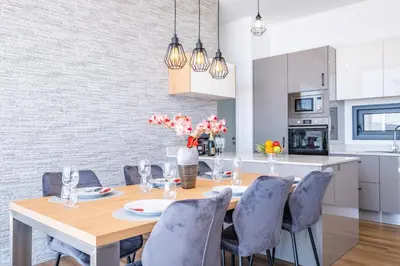 a dining room with a wooden table and blue chairs at Villa Plumeria in Arco da Calheta