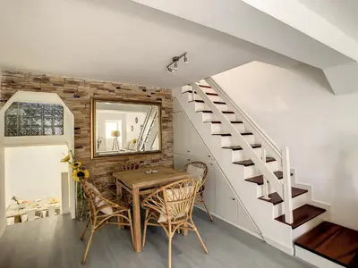 a dining room with a table and a staircase at Casa Safira by LovelyStay in Paul do Mar