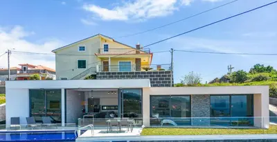 a house with a pool in front of it at Villa Camelia in Arco da Calheta