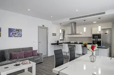a living room and kitchen with a couch and a table at Villa Calhetascape by Villa Plus in Estreito da Calheta