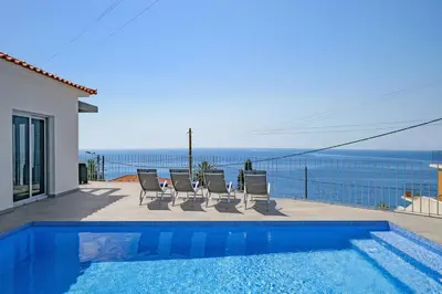 a villa with a swimming pool and a view of the ocean at Villa Calhetascape by Villa Plus in Estreito da Calheta