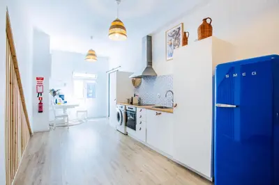 a kitchen with a blue refrigerator and a table at Casa Lugos in Funchal