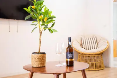 a bottle of wine on a table with a plant at Casa Lugos in Funchal