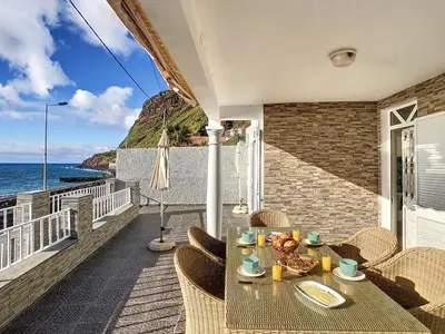 a table and chairs on a balcony with the ocean at Naya Beach House by LovelyStay in Paul do Mar
