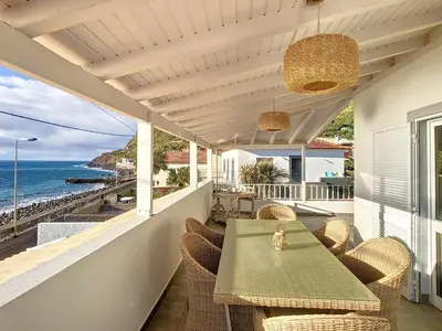 a patio with a table and chairs and the ocean at Naya Beach House by LovelyStay in Paul do Mar