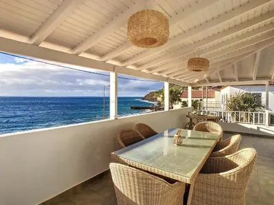 a table and chairs on a balcony with the ocean at Naya Beach House by LovelyStay in Paul do Mar