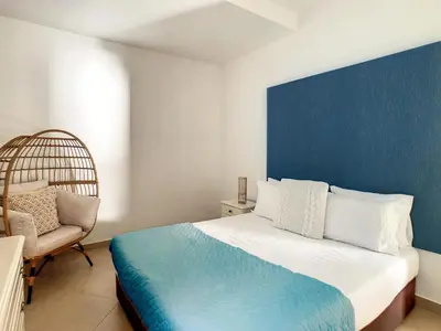 a bedroom with a large bed and a chair at Naya Beach House by LovelyStay in Paul do Mar