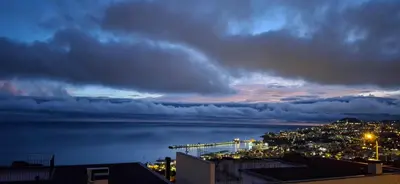 a view of a city and the water at night at Moradia Stephanie in Funchal