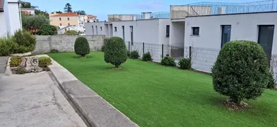 a green yard with trees and a fence at Moradia Stephanie in Funchal