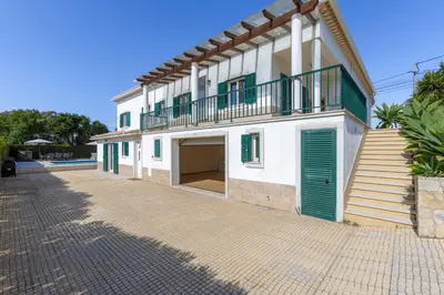 a bedroom with two beds and a kitchen with a table at Good Vibes Villa in Aljezur