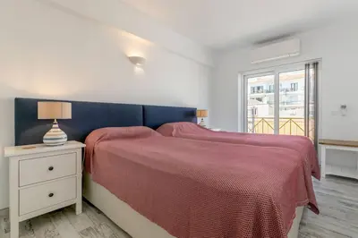 a bedroom with a large bed with a red blanket at Casa Lilas, magnífica vista mar a passos da praia in Luz