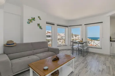 a living room with a couch and a table at Casa Lilas, magnífica vista mar a passos da praia in Luz