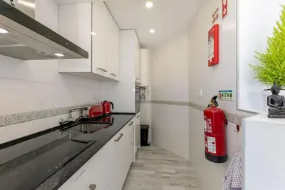 a kitchen with white cabinets and a fire hydrant on the wall at Casa Lilas, magnífica vista mar a passos da praia in Luz