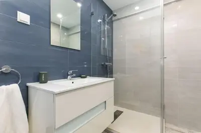 a bathroom with a white sink and a shower at Casa Lilas, magnífica vista mar a passos da praia in Luz