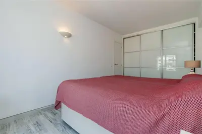 a bedroom with a red bed and a large window at Casa Lilas, magnífica vista mar a passos da praia in Luz