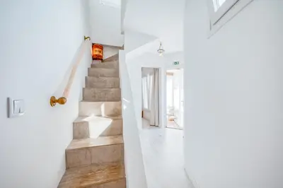 a staircase in a house with white walls and wooden floors at Casa da Rocha in Câmara de Lobos