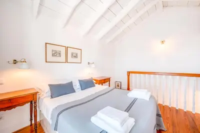 a bedroom with a bed with blue pillows at Casa da Rocha in Câmara de Lobos