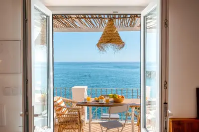 a room with a table and a view of the ocean at Casa da Rocha in Câmara de Lobos