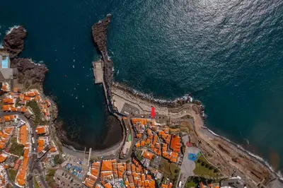 an aerial view of a city next to the ocean at Casa da Rocha in Câmara de Lobos
