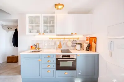 a kitchen with white cabinets and a stove top oven at Casa da Rocha in Câmara de Lobos