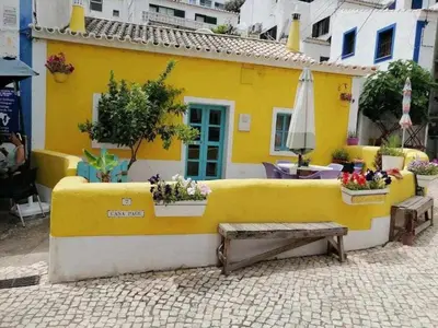 a yellow wall with a bench in front of a building at Burgau Village and Sea in Burgau