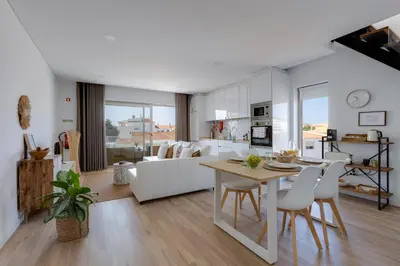 a kitchen and living room with a table and chairs at Burgau Village and Sea in Burgau