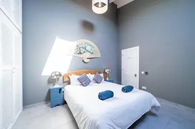 a blue bedroom with a bed with blue pillows on it at Peaceful, spacious & stylish, a real home! in Budens