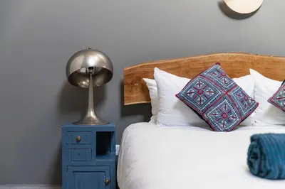a bedroom with a bed with a lamp and pillows at Peaceful, spacious & stylish, a real home! in Budens