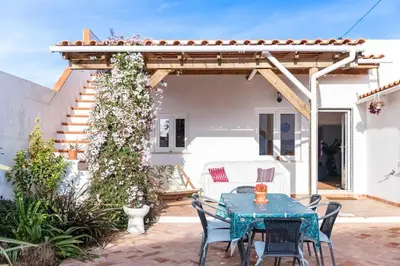 a patio with a table and chairs and a pergola at Peaceful, spacious & stylish, a real home! in Budens