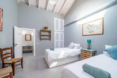 a bedroom with two beds and a table and a chair at Peaceful, spacious & stylish, a real home! in Budens