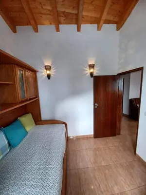 a bedroom with a bed and two lights on the wall at O Refúgio dos Pais in Bordeira