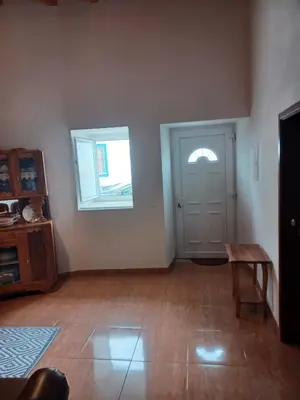 an empty living room with a door and a table at O Refúgio dos Pais in Bordeira