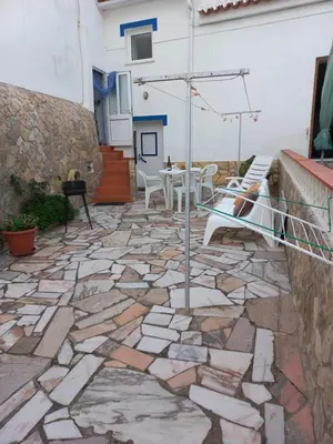 a stone patio with a table and chairs at O Refúgio dos Pais in Bordeira